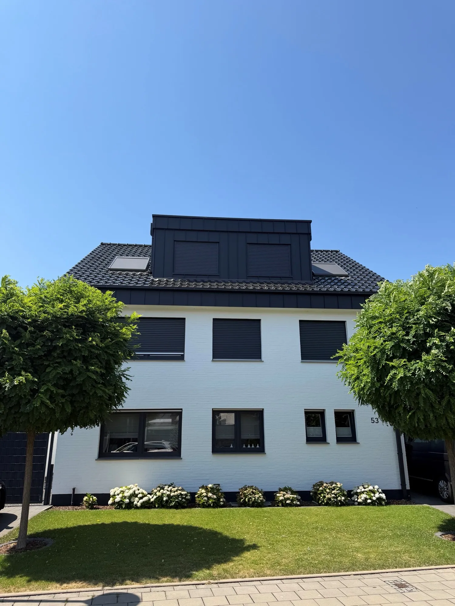 Fertiges Wohnhaus mit neuem anthrazitem Ziegeldach und metallverkleideter Gaube