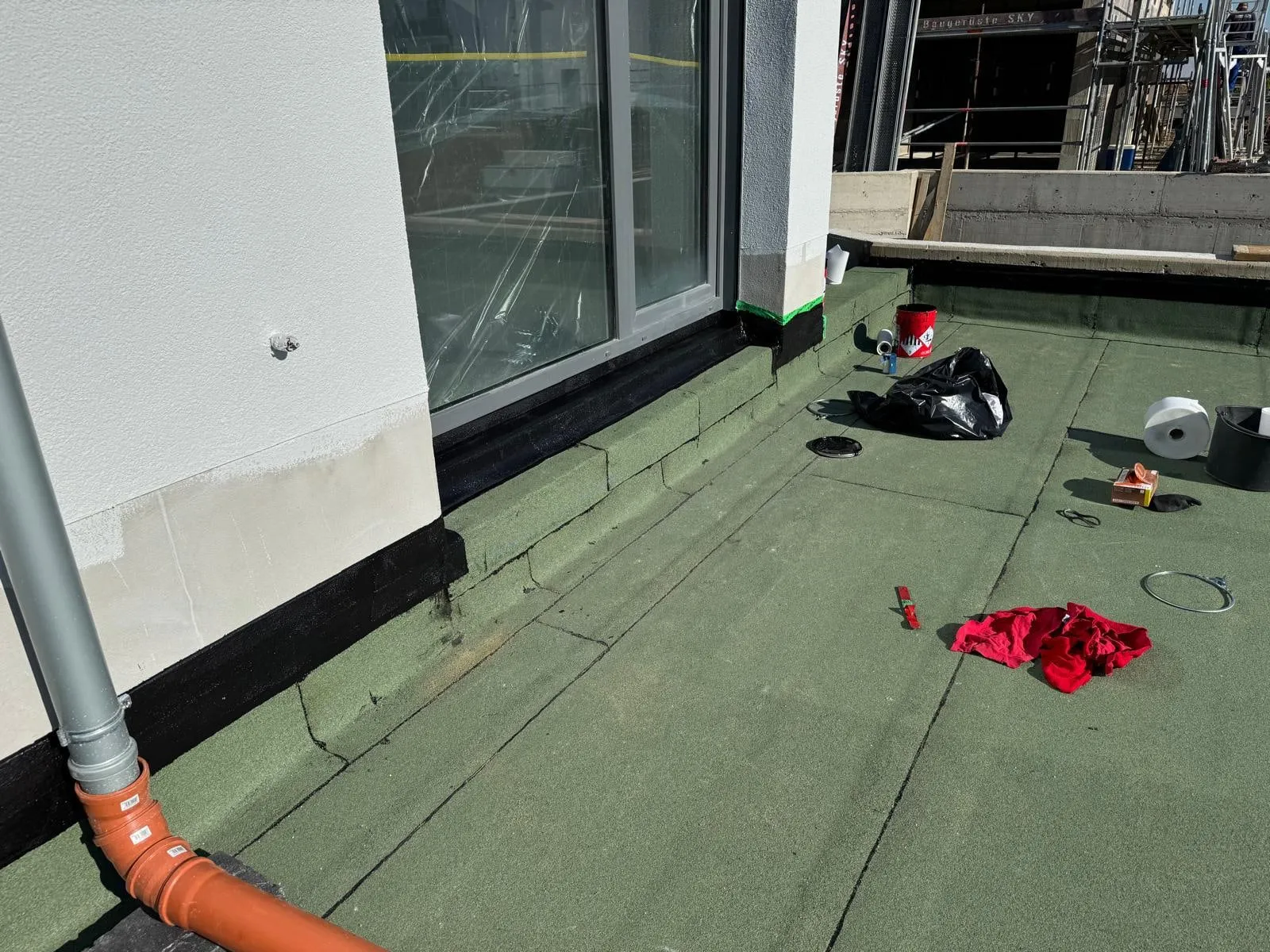 Dachterrasse mit Fallrohranschluss vor den bodentiefen Fenstern