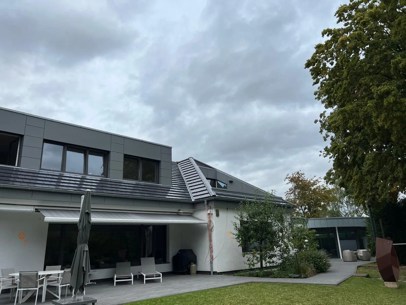 Blick vom Garten auf Terrasse und neues Dach